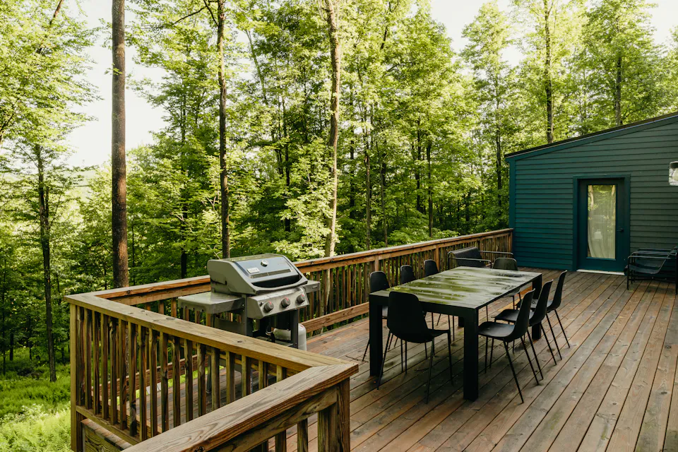 Wooden deck with a railing, set among trees